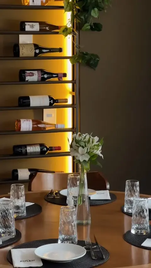 Adega com garrafas iluminadas e mesa posta